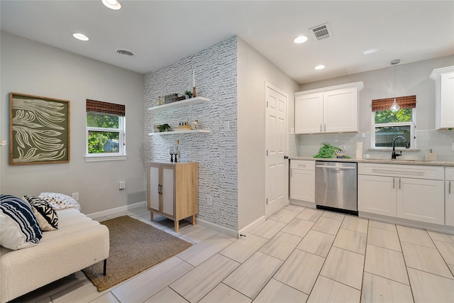 kitchen featuring decorative light fixtures, backsplash, white cabinetry, and stainless steel dishwasher