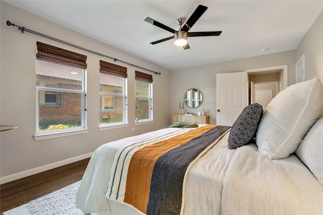 bedroom with ceiling fan, dark hardwood / wood-style flooring, and multiple windows