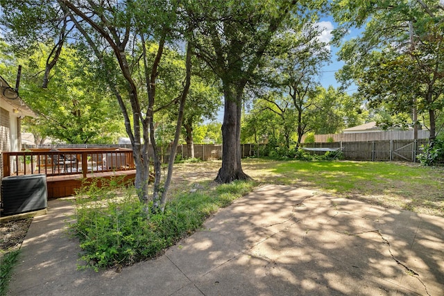 view of yard featuring central air condition unit, a patio area, and a wooden deck