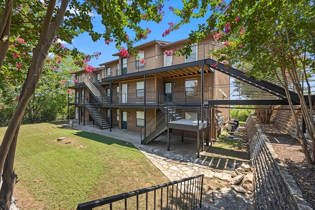 back of property with a yard and a patio