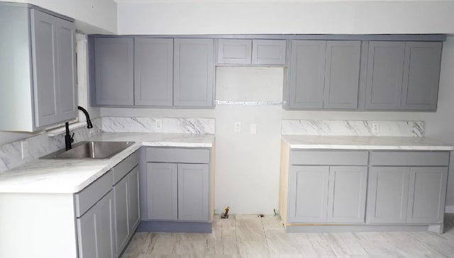 kitchen featuring sink and gray cabinetry