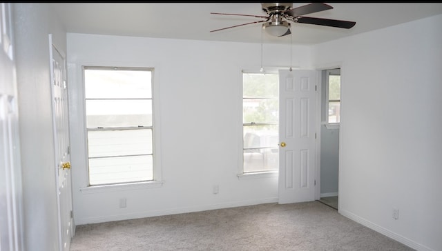 empty room with ceiling fan and light carpet