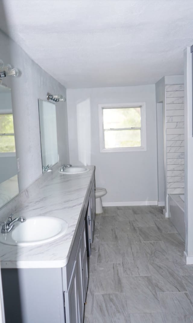 full bathroom featuring a wealth of natural light, vanity, toilet, and tile patterned flooring