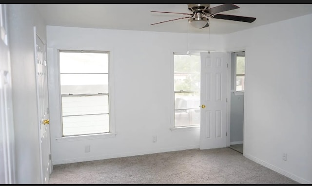 unfurnished room with light colored carpet and ceiling fan