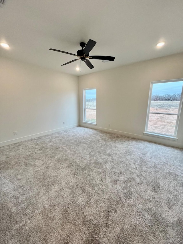 carpeted spare room with ceiling fan