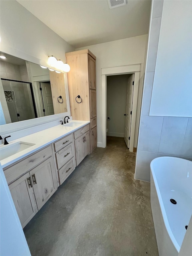 bathroom with vanity, shower with separate bathtub, and concrete floors