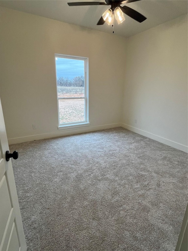 carpeted spare room featuring ceiling fan