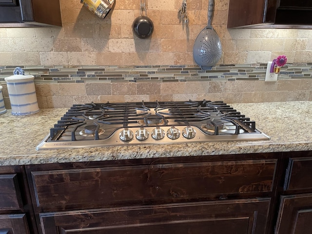 kitchen featuring tasteful backsplash, stainless steel gas stovetop, and dark brown cabinetry