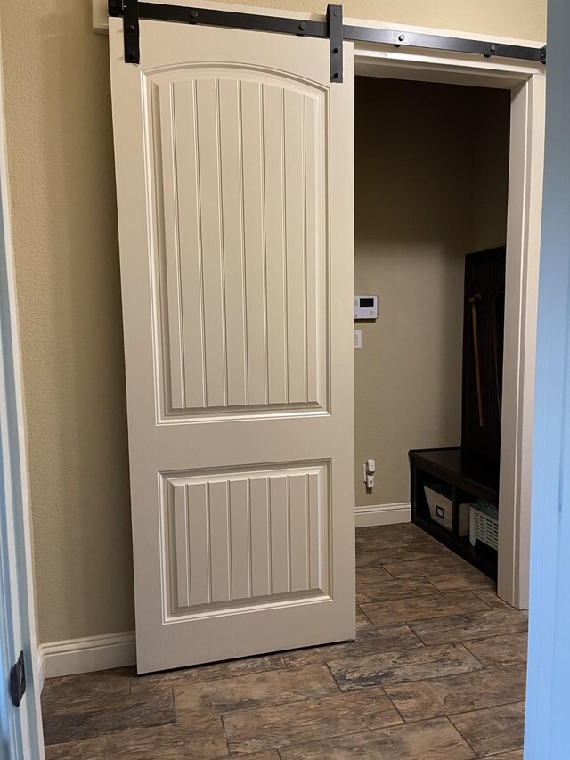 interior space with a barn door and wood-type flooring