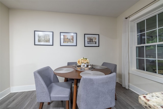 dining area featuring a textured ceiling, an inviting chandelier, wood-type flooring, and a brick fireplace