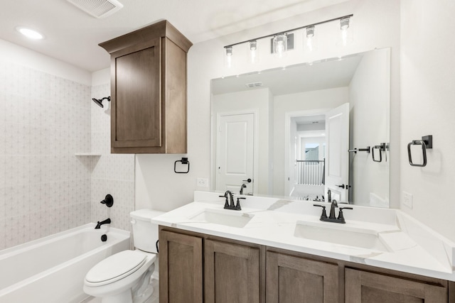 full bathroom featuring tiled shower / bath, vanity, and toilet