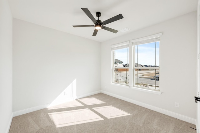 carpeted spare room with ceiling fan