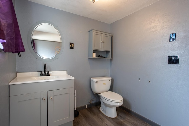 bathroom with vanity, toilet, and hardwood / wood-style floors