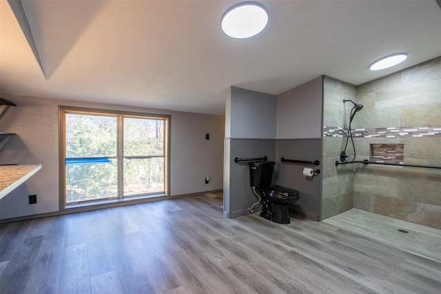 bathroom featuring a tile shower and wood-type flooring