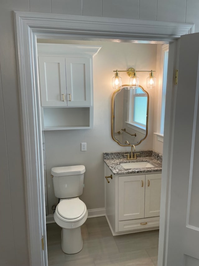 bathroom featuring vanity, toilet, and tile patterned flooring