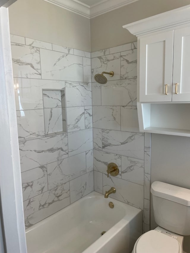 bathroom with tiled shower / bath, crown molding, and toilet