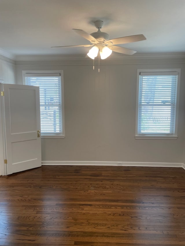 empty room featuring crown molding, dark hardwood / wood-style floors, and a healthy amount of sunlight