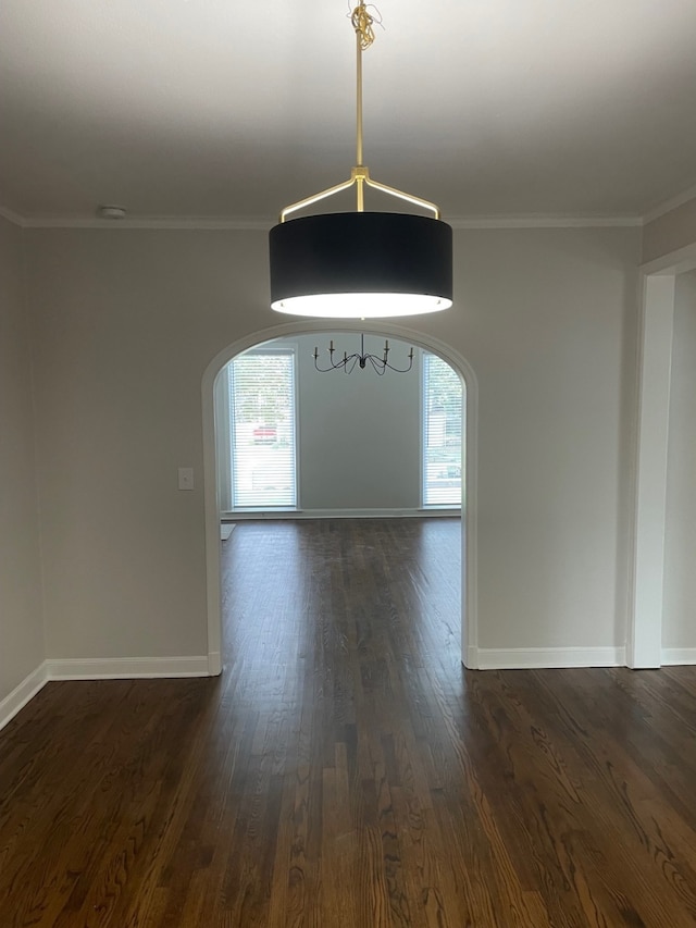 unfurnished dining area with crown molding, plenty of natural light, and dark wood-type flooring