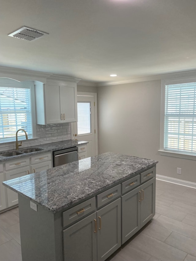 kitchen with sink, white cabinets, a center island, and dishwasher