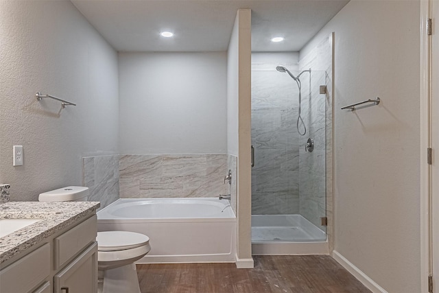 full bathroom with toilet, hardwood / wood-style flooring, plus walk in shower, and vanity