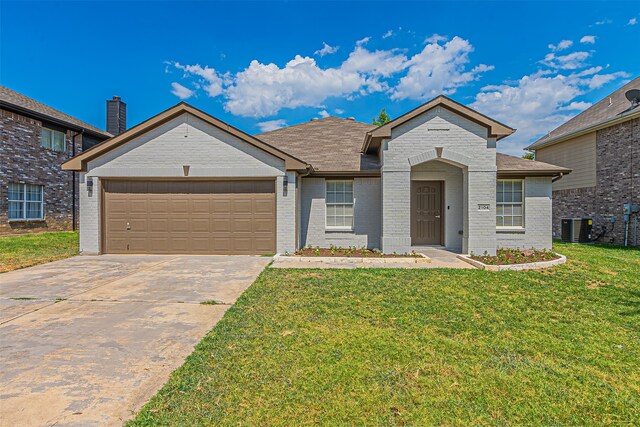 view of front of property featuring cooling unit, a front yard, and a garage