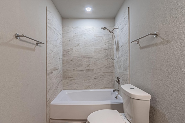 bathroom with toilet and tiled shower / bath combo