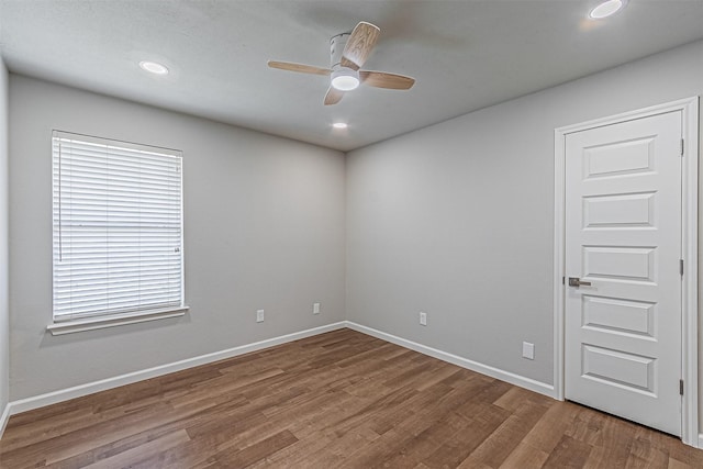 empty room with ceiling fan and hardwood / wood-style flooring