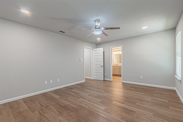 unfurnished bedroom with ceiling fan, connected bathroom, and light hardwood / wood-style flooring