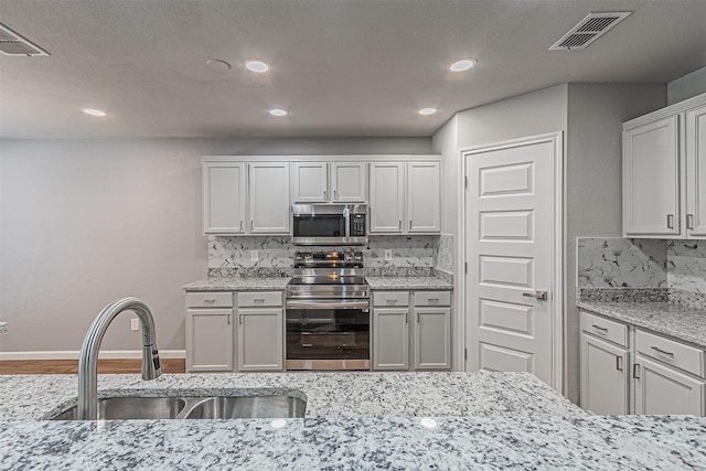 kitchen featuring sink, white cabinetry, stainless steel appliances, and tasteful backsplash