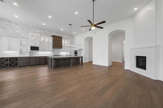 kitchen featuring ceiling fan, a center island with sink, white cabinetry, appliances with stainless steel finishes, and dark hardwood / wood-style flooring