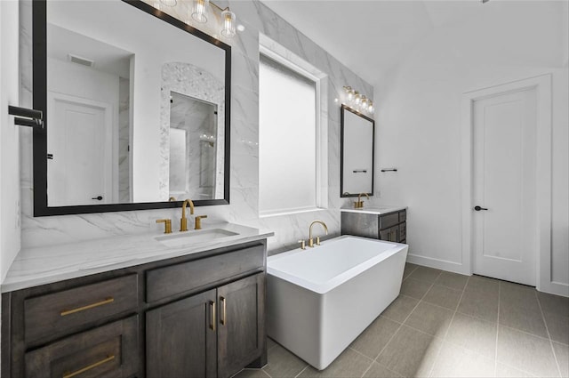 bathroom featuring a tub to relax in, tile walls, and vanity