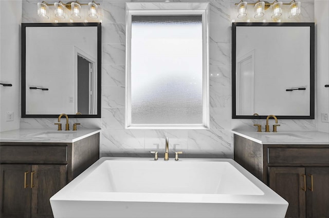 bathroom featuring vanity, a tub, and a wealth of natural light