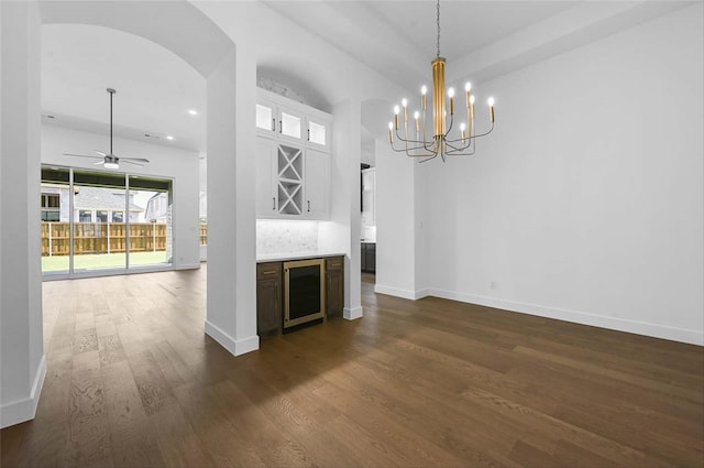 interior space with beverage cooler, ceiling fan with notable chandelier, and dark hardwood / wood-style flooring