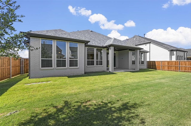 rear view of property featuring a lawn