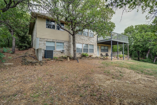 back of property with central AC unit and a wooden deck