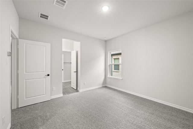 unfurnished bedroom with carpet floors and a spacious closet