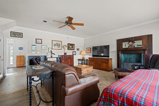 living room featuring light wood-type flooring, ceiling fan, lofted ceiling, and ornamental molding