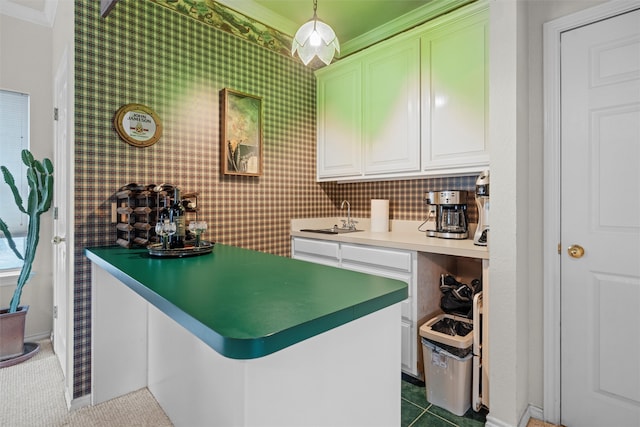 kitchen featuring white cabinets, sink, pendant lighting, kitchen peninsula, and ornamental molding