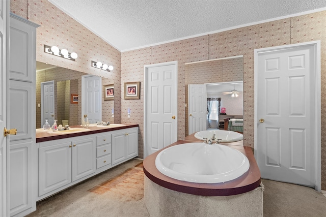 bathroom with a tub to relax in, a textured ceiling, ceiling fan, and dual bowl vanity