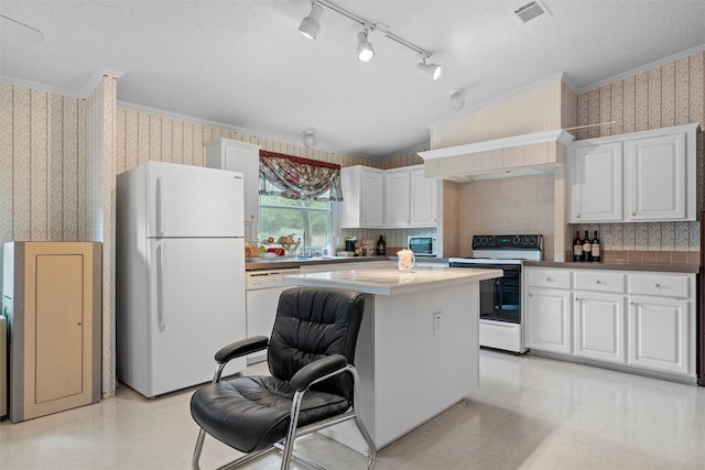 kitchen featuring white cabinets, decorative backsplash, white appliances, a kitchen island, and a textured ceiling