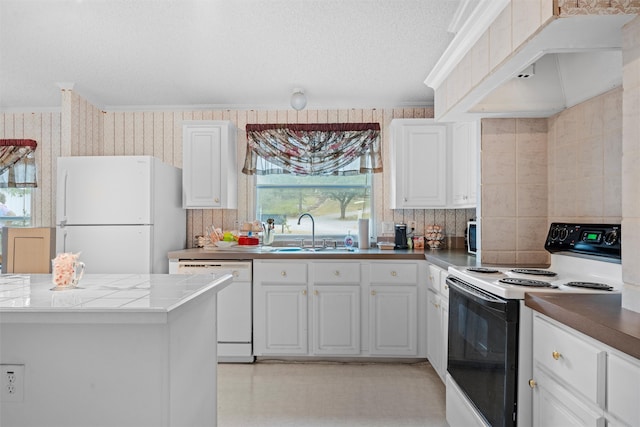 kitchen featuring white cabinetry, sink, white appliances, and custom range hood