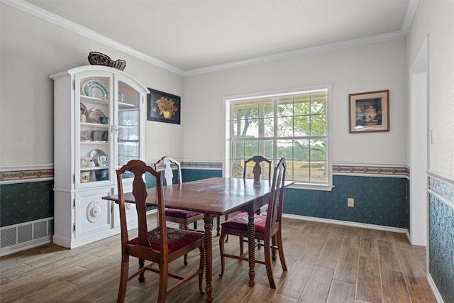 dining space featuring crown molding and light hardwood / wood-style flooring