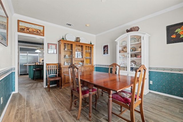 dining space featuring crown molding and hardwood / wood-style floors