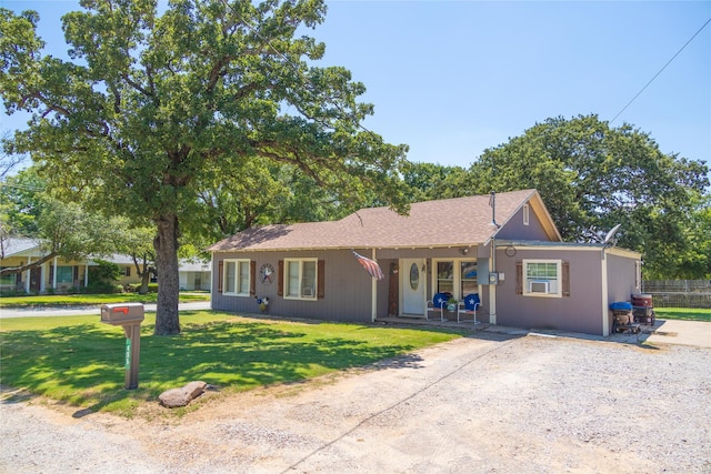 ranch-style home featuring covered porch and a front lawn