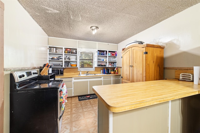 kitchen featuring appliances with stainless steel finishes, a textured ceiling, kitchen peninsula, and sink