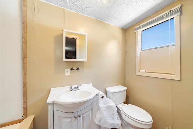 bathroom featuring toilet, a textured ceiling, and vanity