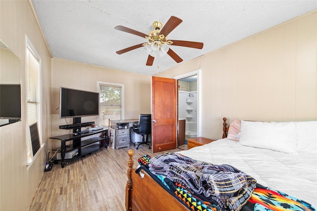 bedroom featuring light hardwood / wood-style flooring, a textured ceiling, and ceiling fan