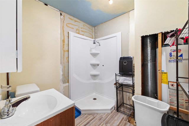 bathroom with water heater, vanity, hardwood / wood-style floors, and walk in shower