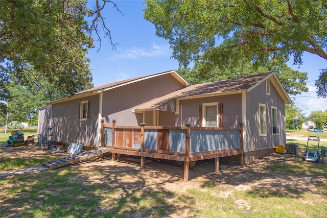 back of house with a wooden deck and a lawn