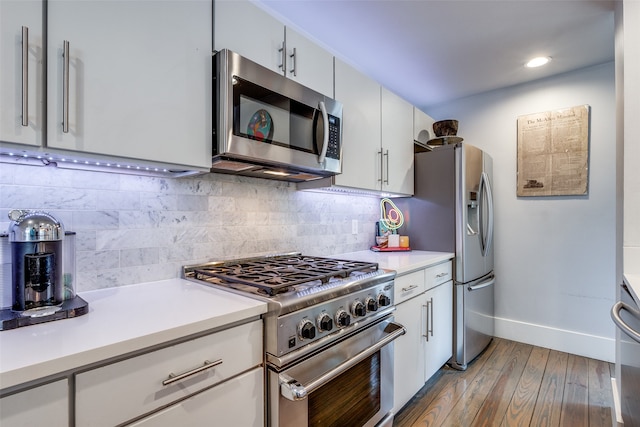 kitchen featuring white cabinets, light hardwood / wood-style flooring, appliances with stainless steel finishes, and backsplash